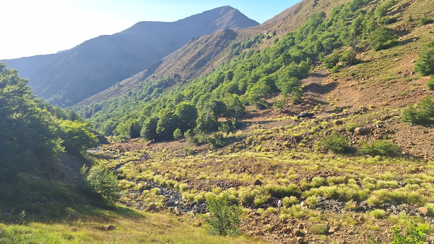 Wide Shebenik mountain valley with a 4x4 vehicle on the trail